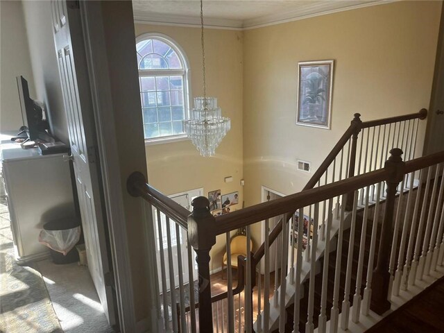 stairway featuring carpet, a notable chandelier, and crown molding