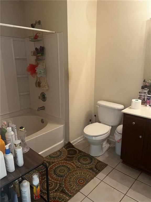 full bathroom featuring toilet, washtub / shower combination, vanity, and tile patterned floors