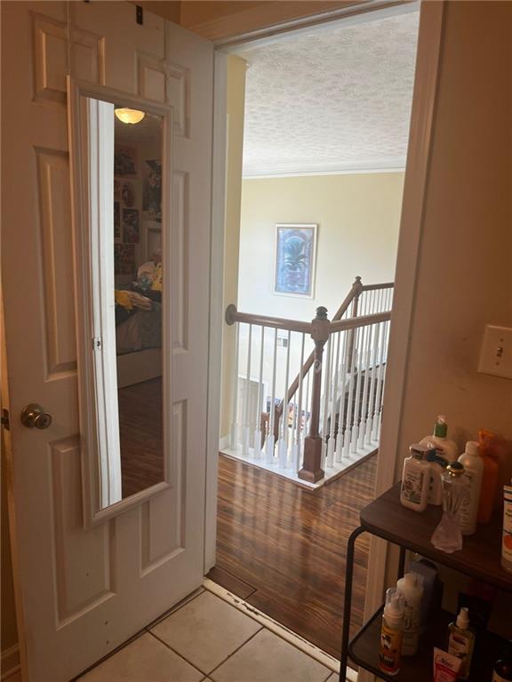 entryway with light wood-type flooring and a textured ceiling