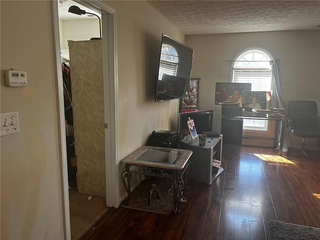 interior space with a textured ceiling and dark hardwood / wood-style floors