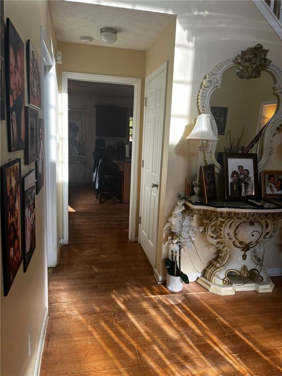 hallway with wood-type flooring and a textured ceiling