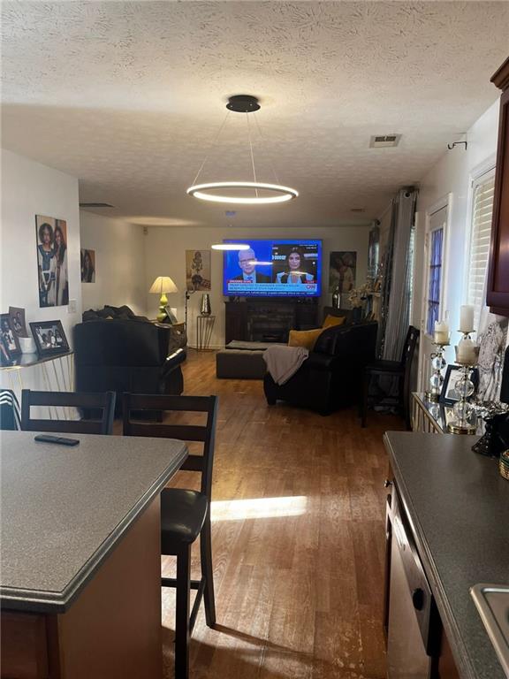 dining space with a textured ceiling and dark hardwood / wood-style floors