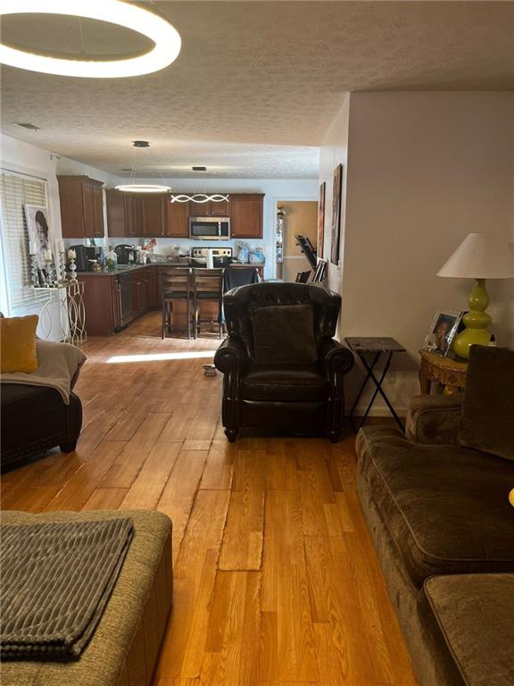 living room featuring light hardwood / wood-style flooring and a textured ceiling