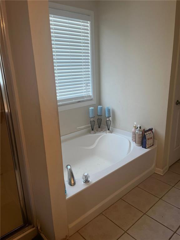 bathroom featuring tile patterned flooring and shower with separate bathtub