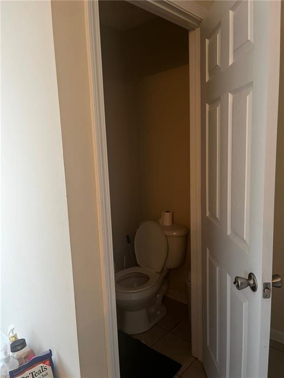 bathroom featuring toilet and tile patterned flooring