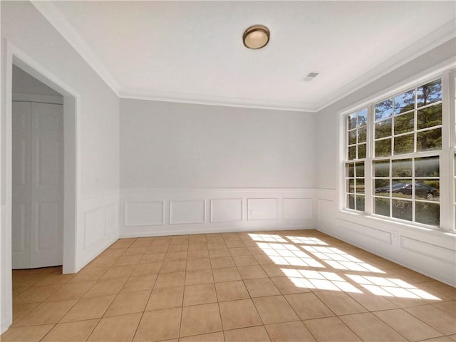 tiled empty room featuring ornamental molding and a healthy amount of sunlight