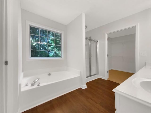 bathroom with hardwood / wood-style floors, vanity, and separate shower and tub