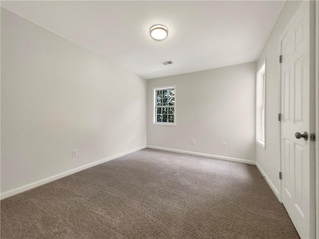 unfurnished room featuring dark carpet