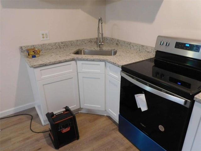 476 W Franklin St, Toccoa, GA 30577 - kitchen with stainless steel range with electric cooktop, light wood-type flooring, white cabinetry, and light stone counters
