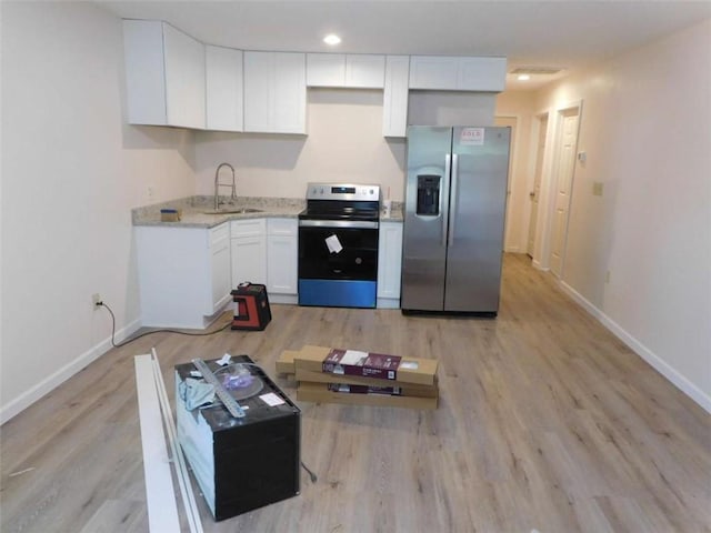 476 W Franklin St, Toccoa, GA 30577 - kitchen with appliances with stainless steel finishes, white cabinetry, light wood finished floors, light stone countertops, and recessed lighting