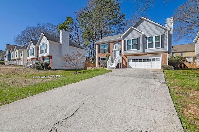 raised ranch featuring a garage, brick siding, concrete driveway, a residential view, and a front yard