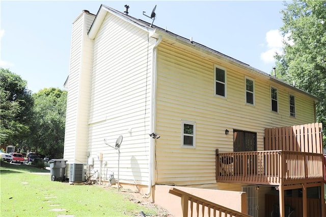 back of property featuring a lawn and central AC