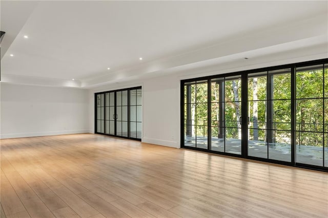 unfurnished room featuring plenty of natural light, recessed lighting, light wood-style floors, and baseboards