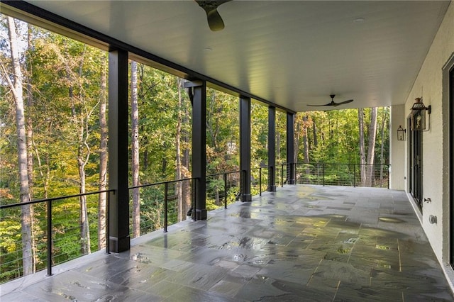 unfurnished sunroom featuring a ceiling fan