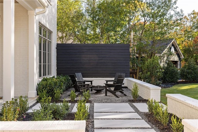 view of patio with a fire pit and fence