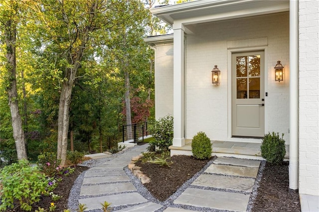 entrance to property featuring brick siding