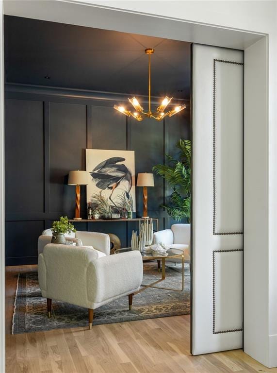 sitting room with wood finished floors and a notable chandelier