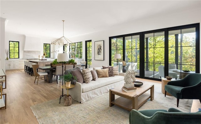 living room featuring a chandelier and light wood-style floors