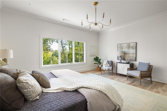 bedroom featuring baseboards, visible vents, light wood finished floors, crown molding, and an inviting chandelier