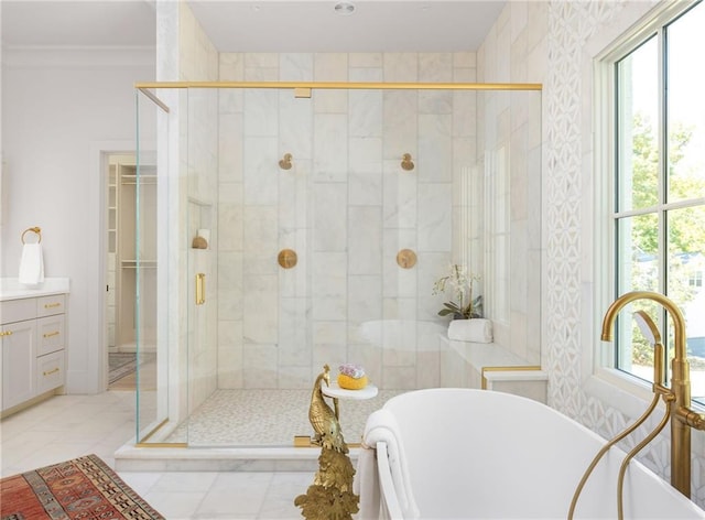 bathroom featuring a stall shower, a soaking tub, a healthy amount of sunlight, and vanity