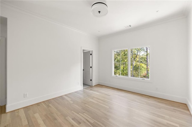 unfurnished room featuring baseboards, ornamental molding, and light wood finished floors