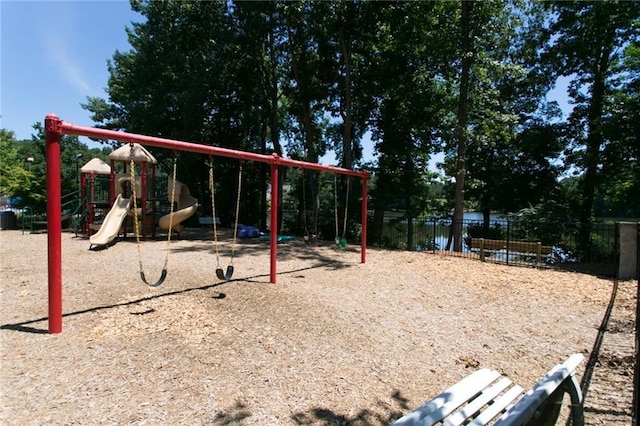 communal playground featuring a water view and fence