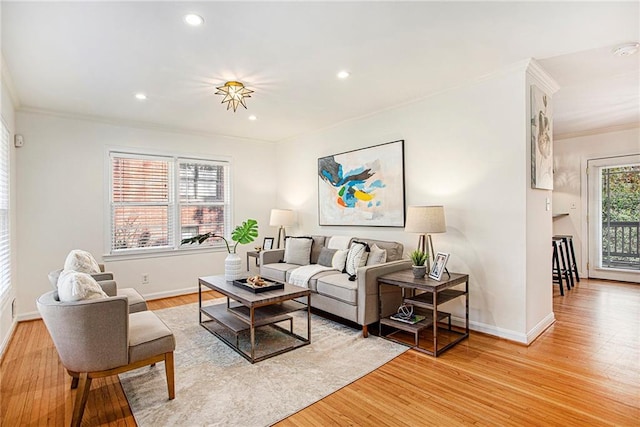 living room with light wood-type flooring and crown molding