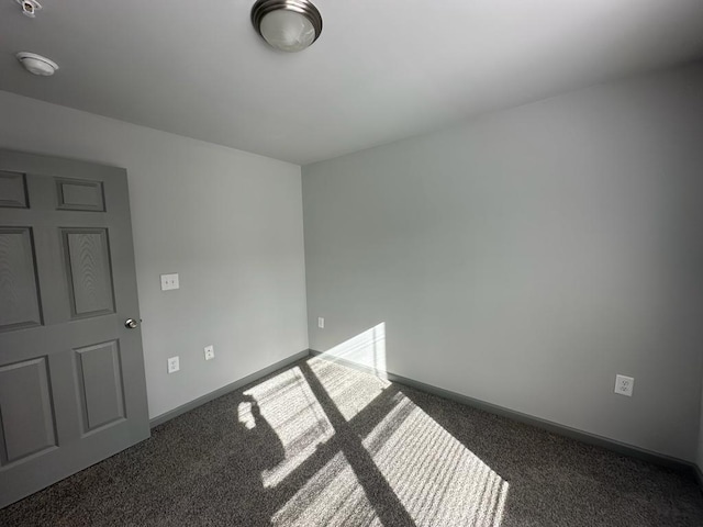 empty room with dark colored carpet