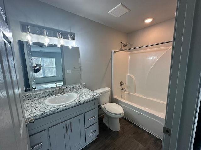 full bathroom featuring hardwood / wood-style flooring, washtub / shower combination, vanity, and toilet