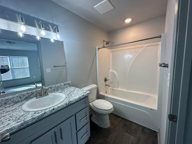 full bathroom with vanity, hardwood / wood-style flooring, toilet, and washtub / shower combination