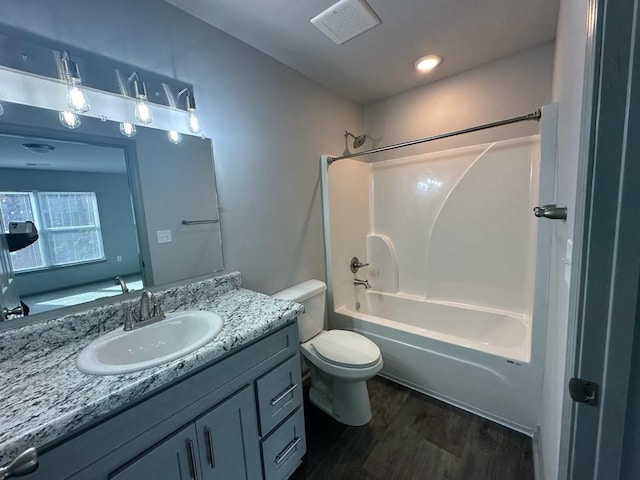 full bathroom featuring wood-type flooring, vanity, washtub / shower combination, and toilet