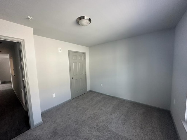 unfurnished room featuring dark carpet