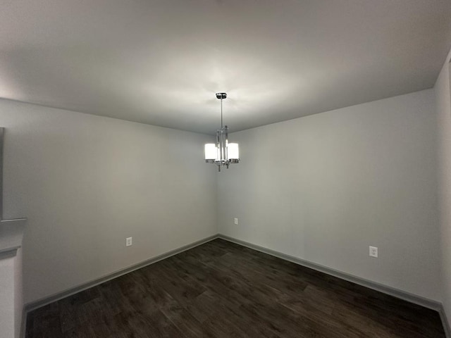 unfurnished dining area with an inviting chandelier and dark hardwood / wood-style floors