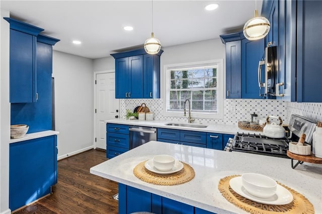 kitchen featuring blue cabinetry, stainless steel appliances, sink, and hanging light fixtures