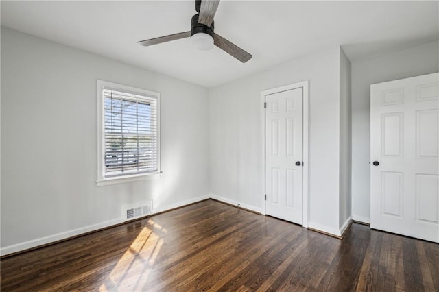 unfurnished bedroom featuring ceiling fan and dark hardwood / wood-style flooring