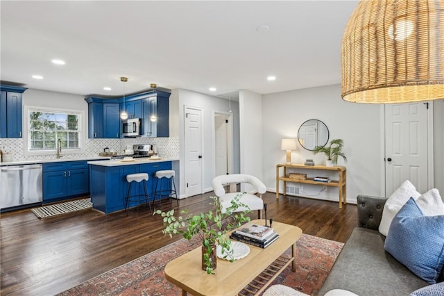 living room featuring dark hardwood / wood-style floors and sink