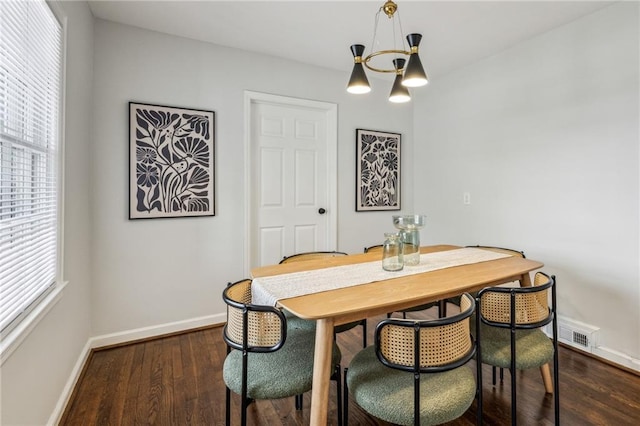 dining space featuring dark hardwood / wood-style flooring and a notable chandelier