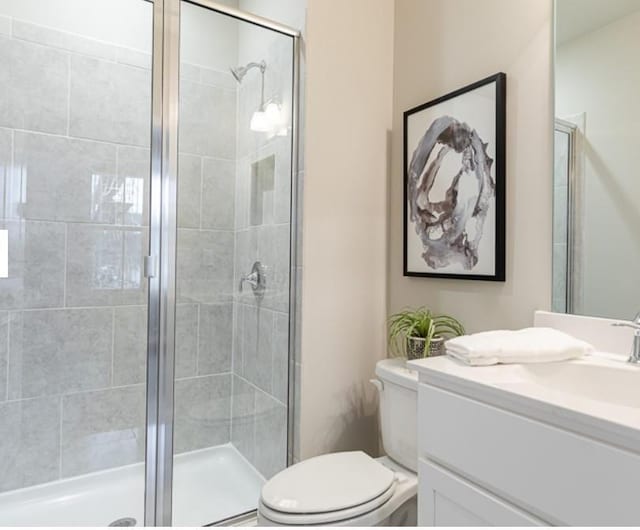 full bath with vanity, toilet, and a shower stall