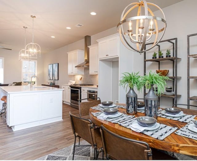 dining space with recessed lighting, wood finished floors, and a chandelier