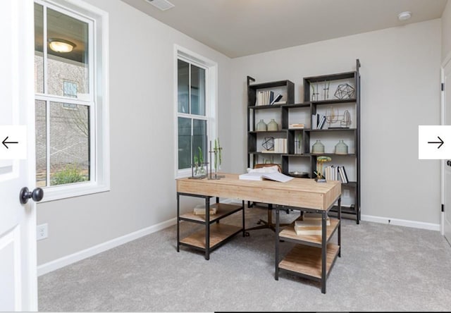 office space featuring visible vents, baseboards, and light carpet