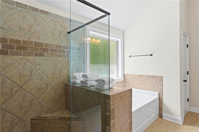 bathroom featuring a tile shower, a garden tub, and tile patterned floors