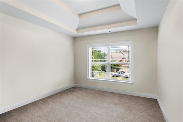 unfurnished room featuring baseboards, visible vents, a tray ceiling, and light colored carpet