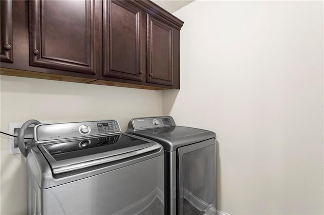 clothes washing area featuring cabinet space and washer and dryer