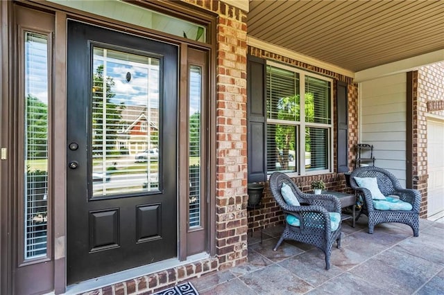 property entrance with a garage and brick siding