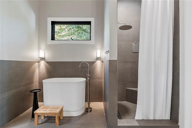 bathroom featuring independent shower and bath and tile walls