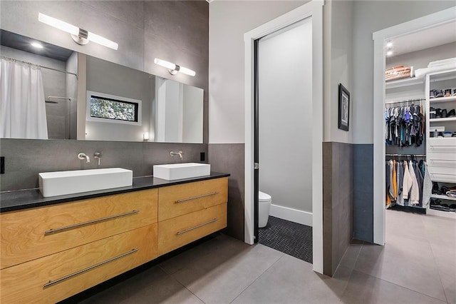 bathroom with tasteful backsplash, vanity, tile patterned floors, and toilet