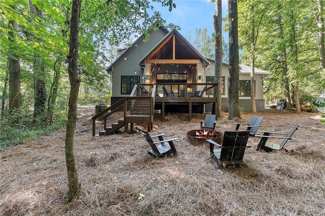 rear view of house with a deck and a fire pit