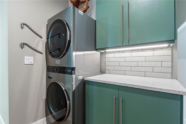 laundry room featuring cabinets and stacked washer and dryer