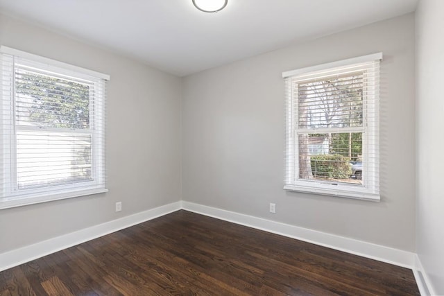 unfurnished room with a healthy amount of sunlight and dark hardwood / wood-style flooring