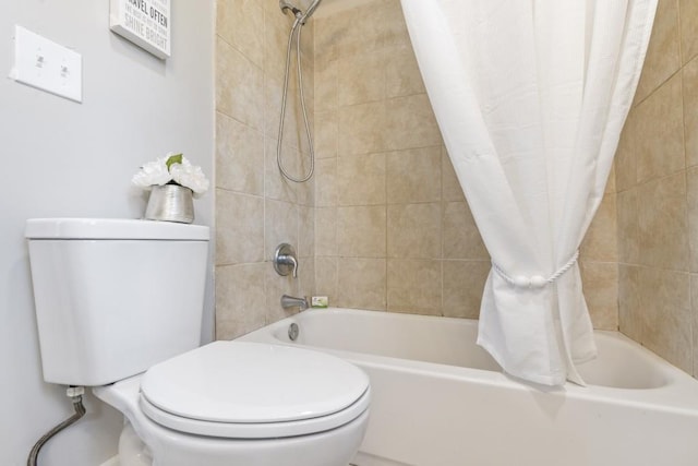 bathroom with shower / tub combo with curtain and toilet